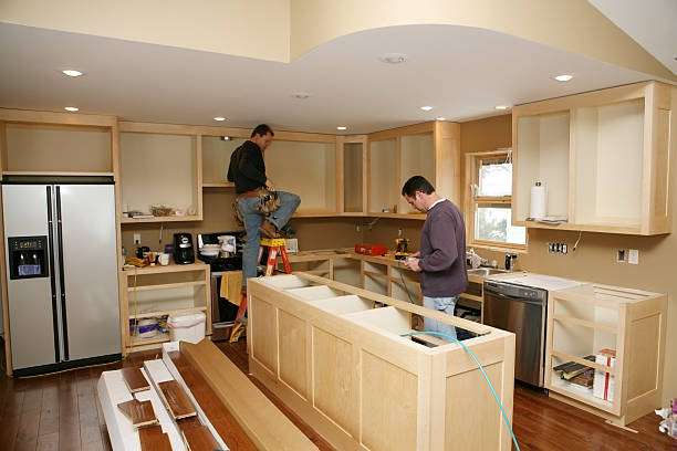 Kitchen Remodel Cabinet maker installing custom made kitchen island and cabinets, while electrician installs in-cabinet lighting.
Very shallow DOF quickly drops off to nice soft focus. the Kitchen Remodel stock pictures, royalty-free photos & images